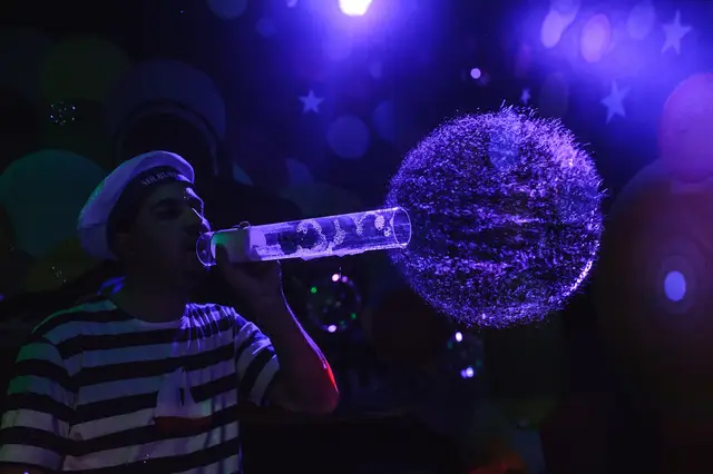 Mr. Bubble fúka veľký bublinový oblak počas UV/blacklight show