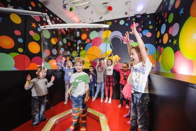 A boy inside a giant bubble surrounded by friends at a party