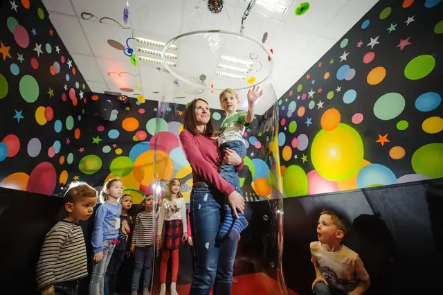 Deti v narodeninových čiapkach fúkajú bublinovú penu